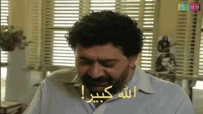 Bearded Man Sitting By Window With Arabic Writing GIF