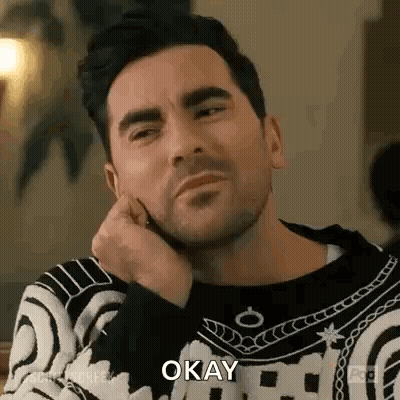 Bearded Man Sitting Hand On Chin Saying Okay GIF