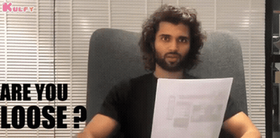 Bearded Man Sitting In Chair Holding Paper Asking Are You Loose GIF