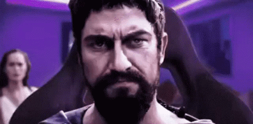 Bearded Man Sitting In Chair Looking At Camera With Woman GIF