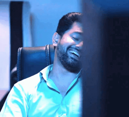 Bearded Man Sitting In Chair Smiling With Eyes Closed GIF