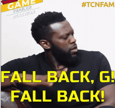 Bearded Man Sitting In Front Of Fall Back G Fall Back Sign GIF