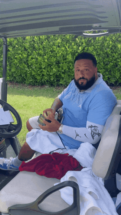 Bearded Man Sitting In Golf Cart Holding Soda GIF