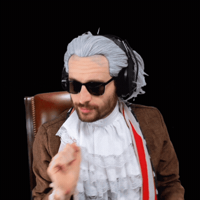 Bearded Man Sitting On Bed Looking At Camera GIF