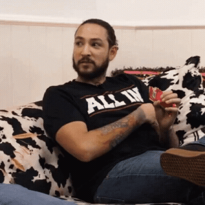 Bearded Man Sitting On Couch In T-Shirt GIF