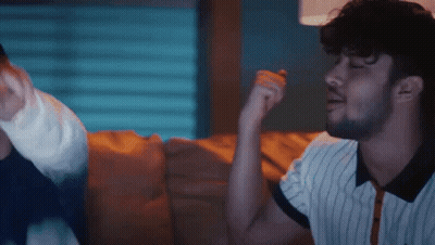 Bearded Man Sitting On Couch Talking To Another Man GIF