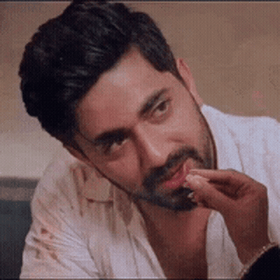 Bearded Man Sitting With Hand On Chin GIF