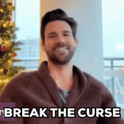 Bearded Man Smiling In Front Of Christmas Tree GIF