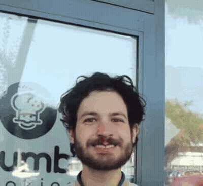 Bearded Man Smiling In Front Of Gumbo Sign GIF