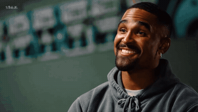 Bearded Man Smiling Next To S.s.a.j. Wall GIF