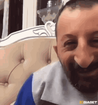 Bearded Man Smiling On Couch GIF