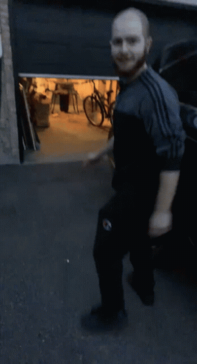 Bearded Man Squatting In Front Of Bike GIF