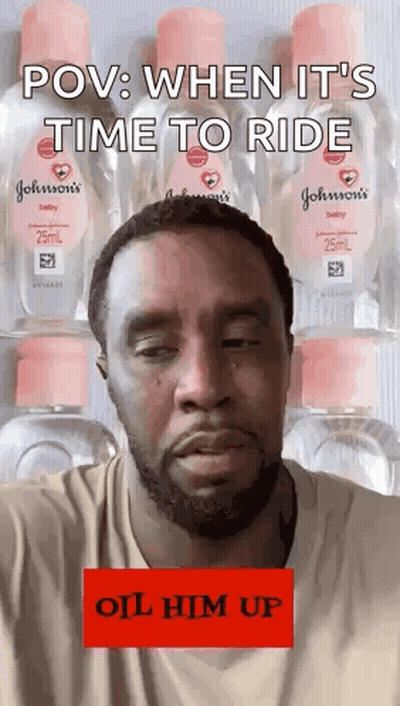 Bearded Man Standing By Baby Oil Bottles GIF