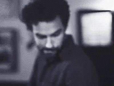 Bearded Man Standing In Dark Room GIF
