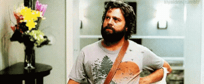 Bearded Man Standing In Front Of Vase Of Flowers GIF