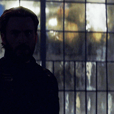 Bearded Man Standing In Front Of Window With Reflection GIF