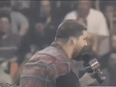 Bearded Man Talking Into Microphone In Crowded Stadium GIF