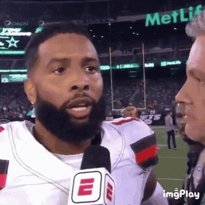 Bearded Man Talking Into Microphone With MetLife Sign GIF