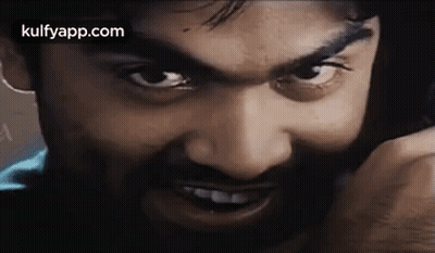 Bearded Man Talking On Cell Phone Looking At Camera GIF