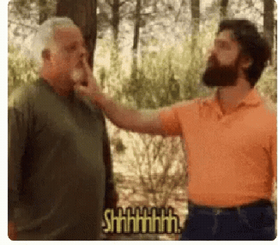 Bearded Man Touching Another Man's Nose in Forest