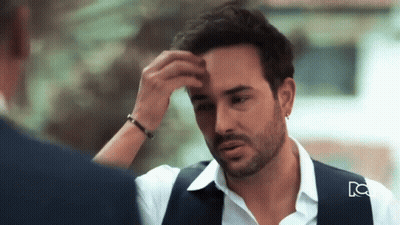 Bearded Man Touching Forehead With Blue Vest GIF