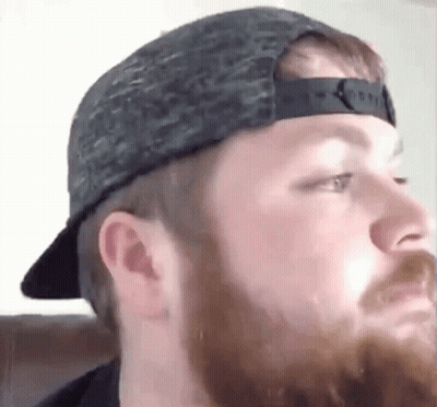 Bearded Man Wearing Hat Looks At Camera GIF