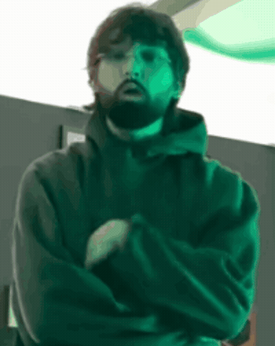 Bearded Man With Arms Crossed In Dark Room GIF