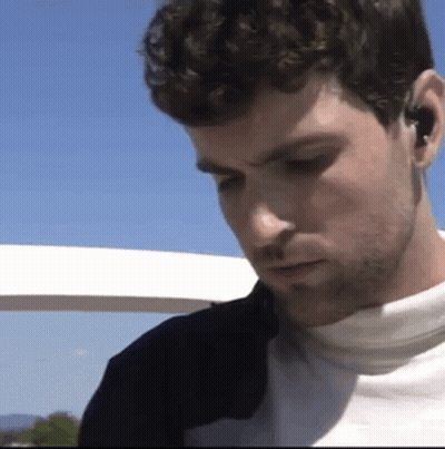 Bearded Man With Earbuds Looking Down GIF
