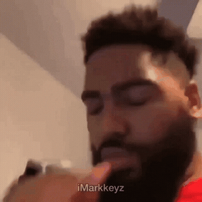 Bearded Man With Finger To Mouth Looking At Phone GIF
