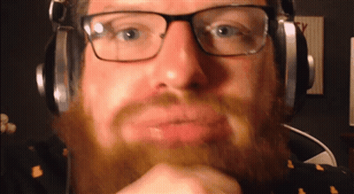 Bearded Man With Glasses And Headphones Looking At Camera GIF