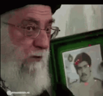 Bearded Man With Glasses Holding Picture In Green Frame GIF