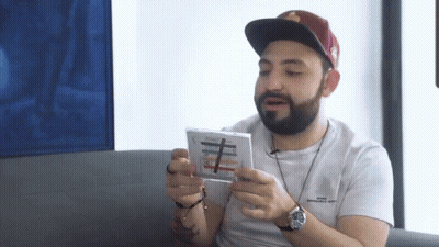 Bearded Man With Hat And Watch Holding CD GIF