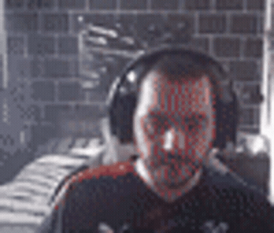 Bearded Man With Headphones By Brick Wall GIF