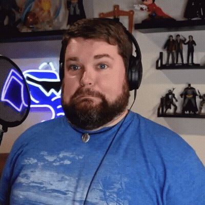 Bearded Man With Headphones In Blue Shirt At Microphone GIF