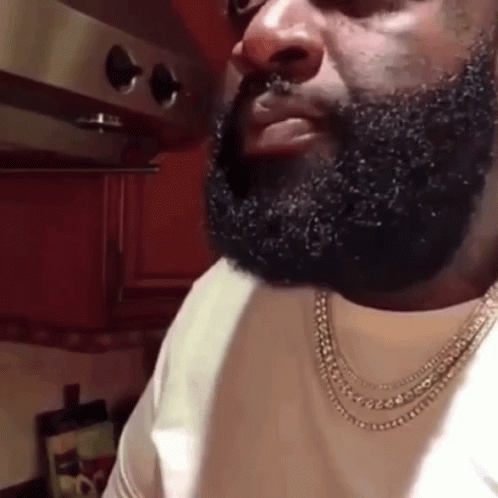 Bearded Man With Necklace In Kitchen GIF