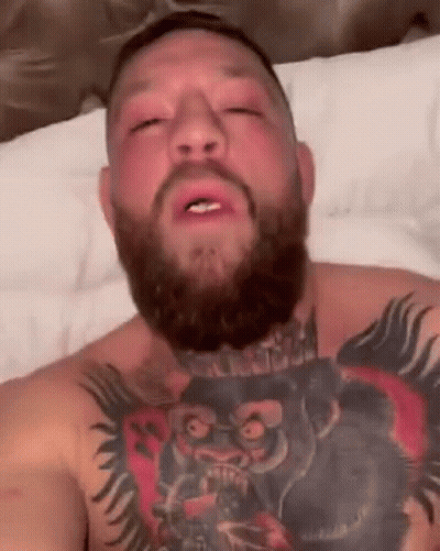 Bearded Man With Tattoos Lying On Bed GIF