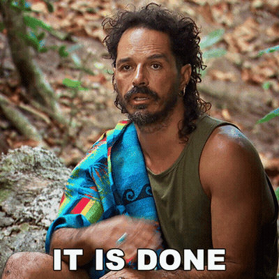 Bearded Man With Towel Sitting On Rock Says It Is Done GIF