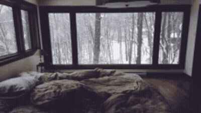 Bedroom With Bed And Snowy Forest View GIF