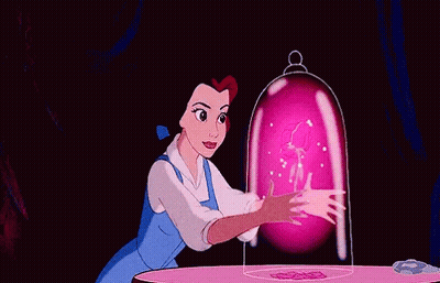 Belle From Beauty And The Beast Is Sitting At A Table With A Pink Flower Coming Out Of Her Hand . GIF