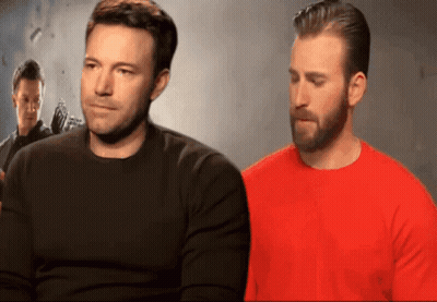 Ben Affleck And Chris Evans Are Sitting Next To Each Other In Front Of A Wall GIF