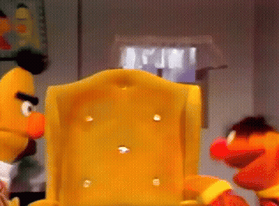 Bert And Elmo From Sesame Street Are Sitting In A Chair GIF