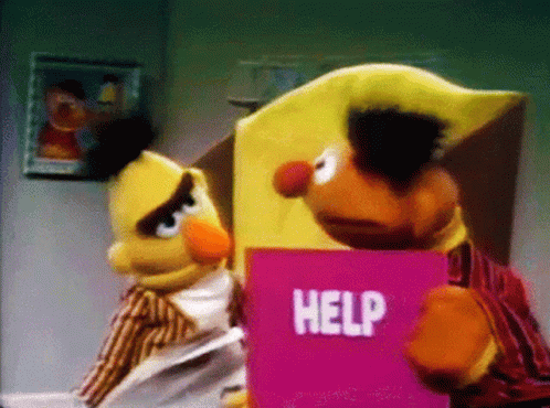 Bert and Ernie Holding Pink Help Sign