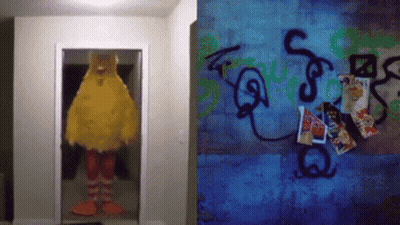Big Bird Mascot Standing In Doorway Next To Graffiti Wall GIF
