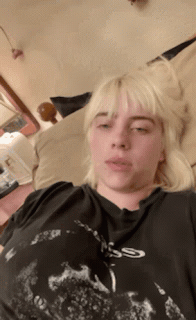 Billie Eilish Laying On Bed In Black Skull T-Shirt GIF