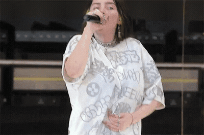 Billie Eilish Singing Into Microphone With White Shirt GIF