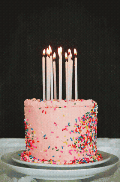 Birthday Cake With Pink Frosting And Sprinkles And Lit Candles GIF