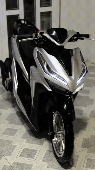 Scooter negro y plateado estacionado frente a la puerta GIF