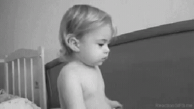 Black And White Baby Sitting On Bed GIF
