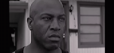 Black And White Bald Man Looking At Camera Before House GIF