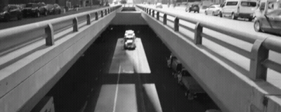 Black And White Car Driving Under Bridge GIF